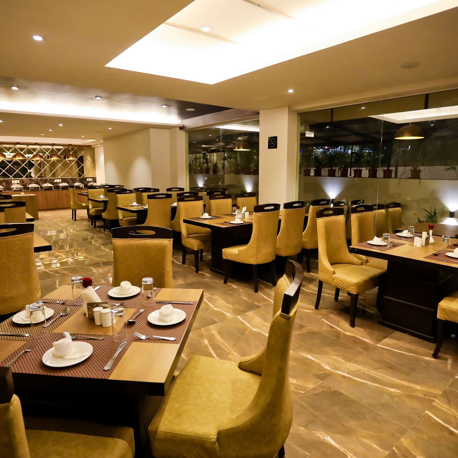 Image of a dining space with crockery placed on the tables and chairs surrounding it at Calux Grand Baga.